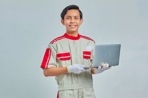Stilig Ung Mekaniker Man Bär Uniform Innehav Laptop Och Tittar — Stockfoto