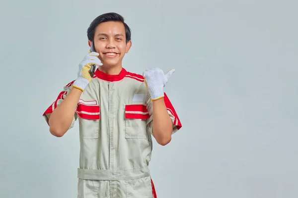Portrét Šťastný Mladý Hezký Mechanik Muž Uniformě Mluví Mobilu Ukazuje — Stock fotografie