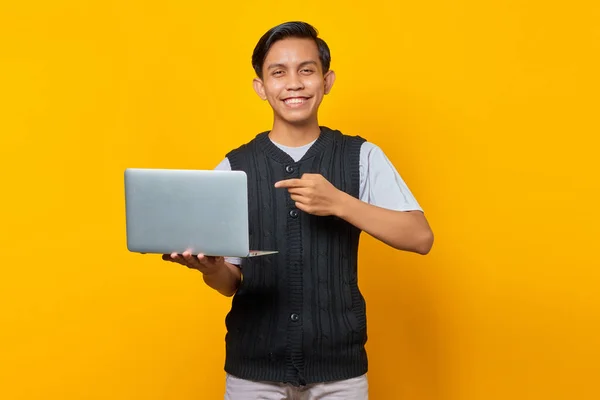 Усміхнений Красивий Молодий Чоловік Вказує Палець Ноутбук Жовтому Тлі — стокове фото
