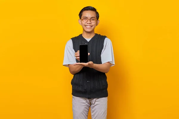Fröhlicher Asiate Zeigt Smartphone Bildschirm Auf Gelbem Hintergrund — Stockfoto