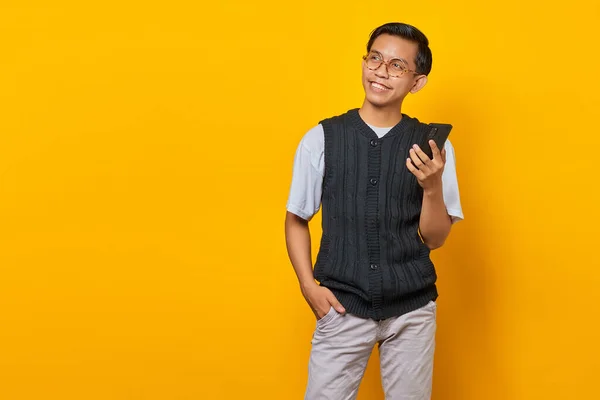 Усміхаючись Молодий Азіат Розмовляє Мобільному Телефону Дивиться Убік Жовте Тло — стокове фото