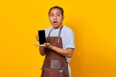 Afallamış Asyalı adam avuç içi ile boş akıllı telefon ekranı gösteriyor. ürün tanıtım kavramı