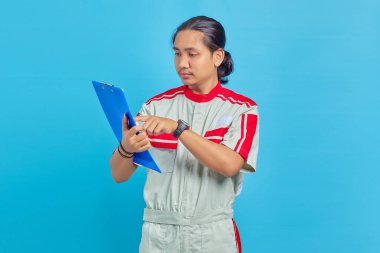 Üniformalı gülümseyen yakışıklı mekanik adamın portresi mavi arka planda parmağı olan panoya işaret ediyor.