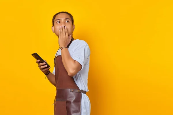 Scioccato Asiatico Uomo Coprendo Bocca Con Mani Tenendo Smartphone Sfondo — Foto Stock