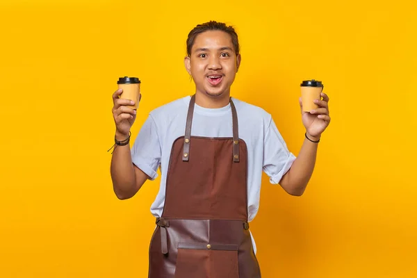 あなたのためにあなたが選択するために2つの紙コーヒーカップを持っている陽気なバリスタ男の肖像画黄色の背景に隔離 — ストック写真