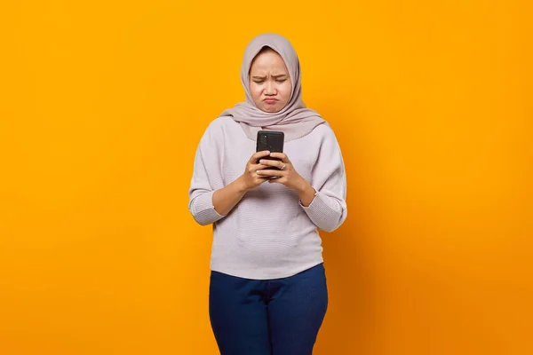 Портрет Злой Азиатки Использующей Мобильный Телефон Жёлтом Фоне — стоковое фото
