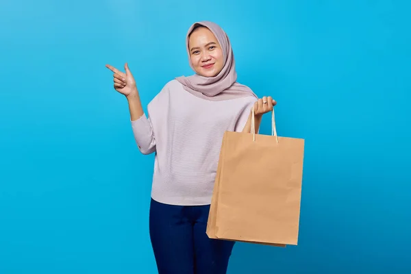 Portrait Cheerful Asian Woman Holding Shopping Bag Pointing Finger Empty — Stok Foto