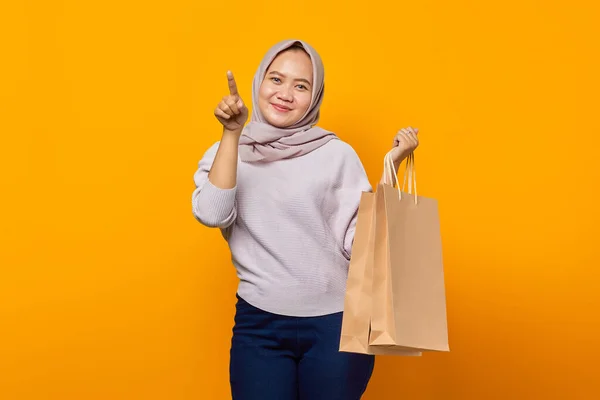 笑みを浮かべてアジアの女性の肖像ショッピングバッグを保持し 指を指して空のスペース — ストック写真