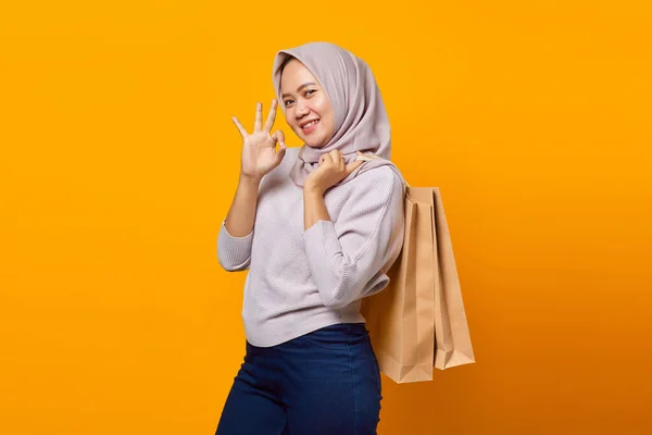 Potret Wanita Asia Tersenyum Memegang Tas Belanja Dan Membuat Tanda — Stok Foto