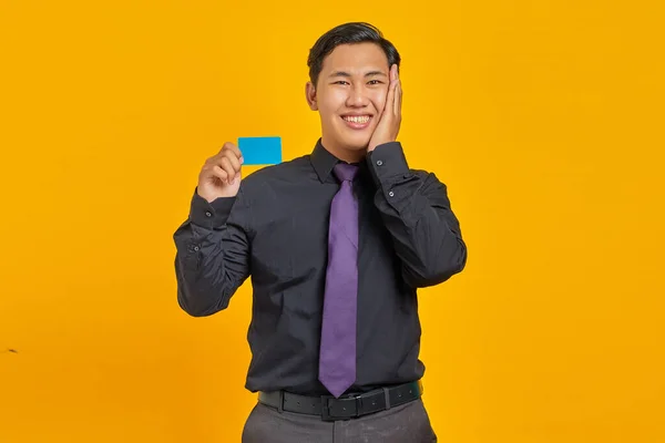 Щасливий Азіатський Бізнесмен Який Тримає Кредитну Картку Торкається Щоки Жовтому — стокове фото