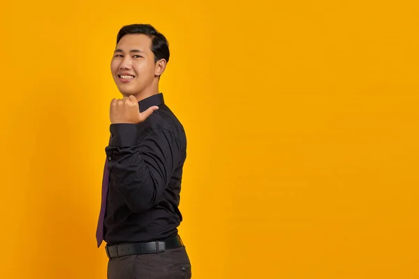Lächelnder Junger Gutaussehender Geschäftsmann Zeigt Mit Dem Finger Auf Kopierraum — Stockfoto