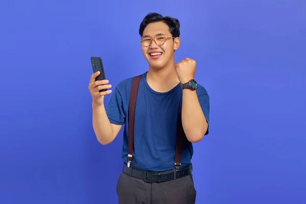 Веселий Молодий Чоловік Використовує Смартфон Святкує Успіх Фіолетовому Фоні — стокове фото
