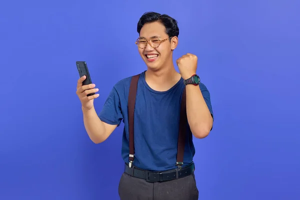 Χαρούμενος Νεαρός Άνδρας Που Χρησιμοποιεί Smartphone Και Γιορτάζει Την Επιτυχία — Φωτογραφία Αρχείου