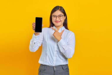 Neşeli iş kadınının boş akıllı telefon ekranı gösteren ve kameraya bakarken onu gösteren fotoğrafı.