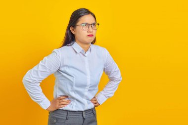 Kafası karışmış genç iş kadınının fotoğrafı sarı arka plana bakıyor.