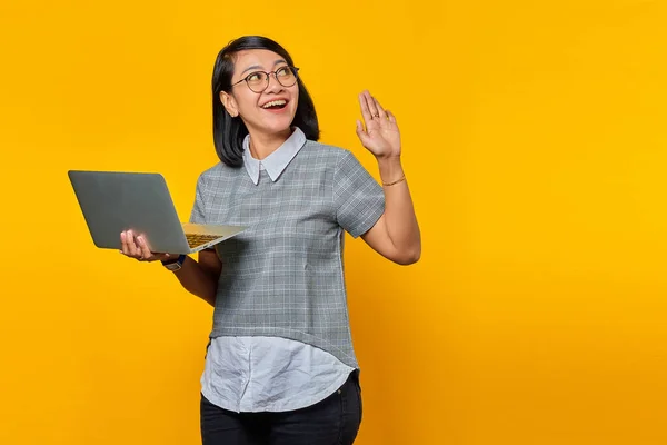 Cheerful Young Asian Woman Holding Laptop Looking Aside Waving Yellow — Stock Photo, Image