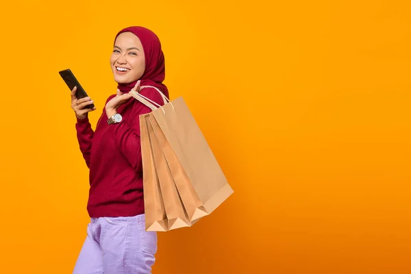 Joyeux Asiatique Femme Tenant Smartphone Montrant Sacs Provisions Sur Fond — Photo