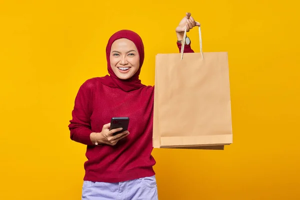 Vidám Fiatal Ázsiai Gazdaság Smartphone Bemutató Bevásárló Táskák Sárga Alapon — Stock Fotó