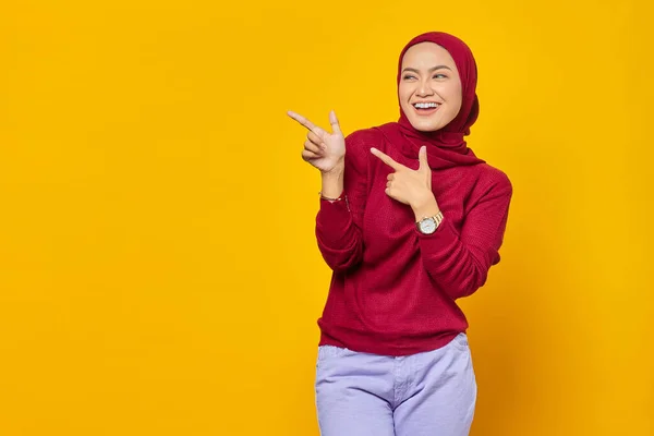 Portret Uśmiechniętej Młodej Azjatki Wskazującej Palcem Przestrzeń Żółtym Tle — Zdjęcie stockowe