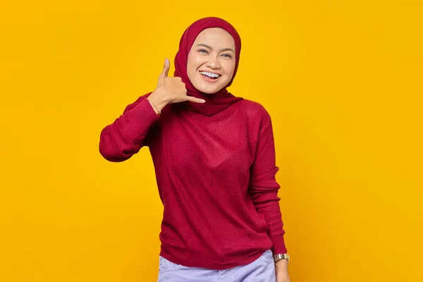 快乐的亚裔穆斯林女人在黄色背景上摆出打电话的姿势 — 图库照片