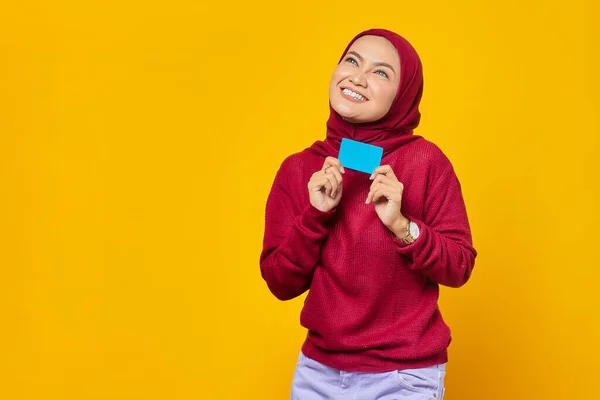 Smiling Young Asian Woman Holding Credit Card While Looking Aside — Stok Foto