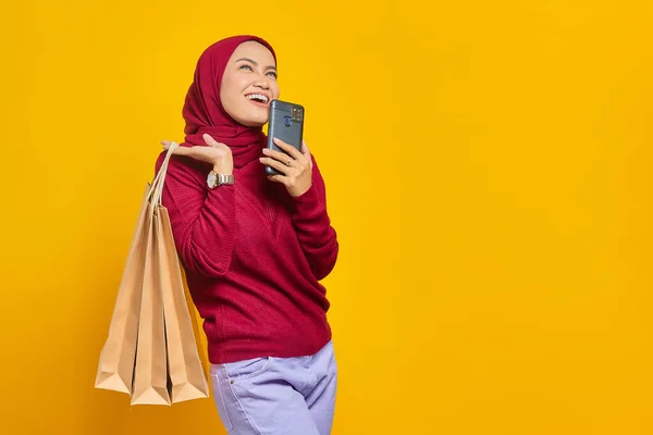 Mosolygó Fiatal Ázsiai Mobiltelefon Gazdaság Bevásárló Táskák Sárga Háttér — Stock Fotó
