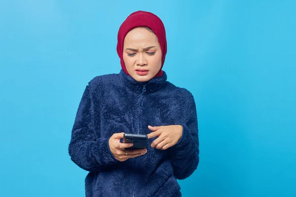 Злая Молодая Азиатка Использующая Мобильный Телефон Смотрящая Экран Смартфона Синем — стоковое фото