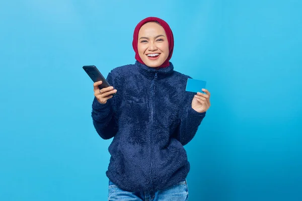 Портрет Улыбающейся Молодой Азиатки Держащей Мобильный Телефон Показывающей Кредитку Синем — стоковое фото