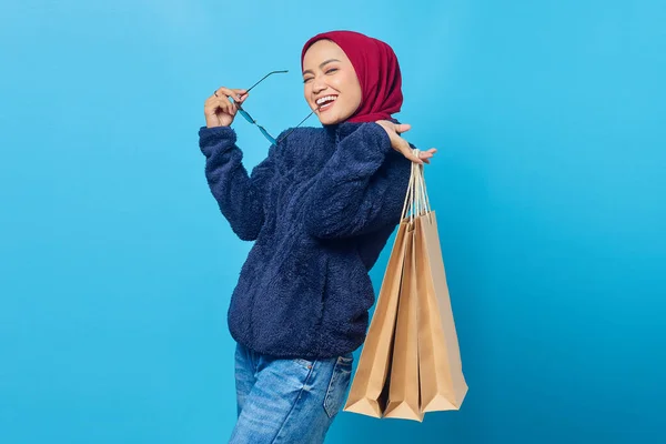 Joven Mujer Asiática Alegre Mordiendo Gafas Sosteniendo Bolso Compras Sobre —  Fotos de Stock