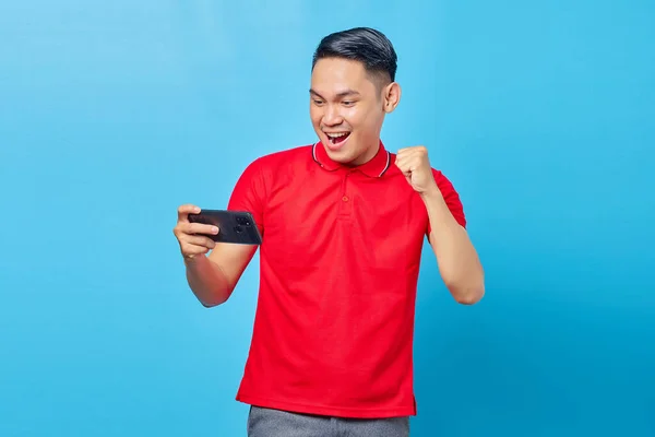 Heyecanlı Asyalı Genç Adamın Portresi Cep Telefonuyla Oyun Oynuyor Mavi — Stok fotoğraf