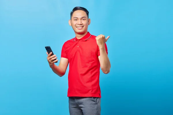 Fröhlicher Junger Asiatischer Mann Hält Handy Der Hand Und Zeigt — Stockfoto