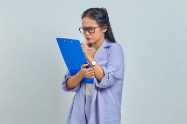 Genç Asyalı iş kadınının portresi. Yazı planlama notları. Satış stratejisini mor arka planda izole ediyor.