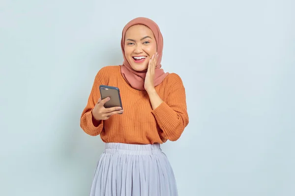 Joven Mujer Musulmana Asiática Alegre Suéter Marrón Hijab Sosteniendo Teléfono —  Fotos de Stock