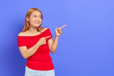 Mor arka planda izole bir şekilde fotokopi odasında duran sarı saçlı çekici genç Asyalı kadın portresi.