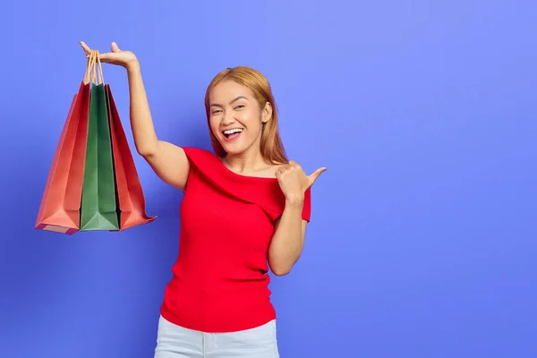 Vidám Fiatal Ázsiai Bemutató Bevásárló Táskák Ujjal Mutogatva Másolás Tér — Stock Fotó