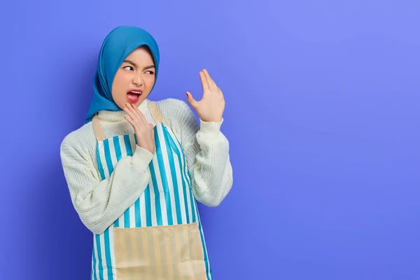 身穿头巾和条纹围裙 怒气冲冲的年轻亚洲穆斯林妇女的画像 手心不支 没有紫色背景的孤立 人们家庭妇女穆斯林生活方式的概念 — 图库照片
