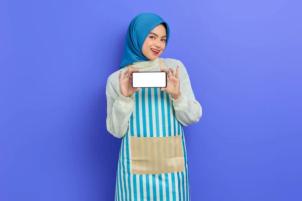Wesoła Młoda Azjatycka Muzułmanka Nosząca Hidżab Fartuch Trzymająca Pusty Ekran — Zdjęcie stockowe
