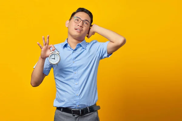 Pensive Handsome Asian Young Man Glasses Showing Alarm Clock Looking — Stock Photo, Image