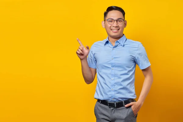 年轻的亚洲男子戴着眼镜 手指指向黄色背景上孤立的复制空间的肖像 商人和企业家概念 — 图库照片