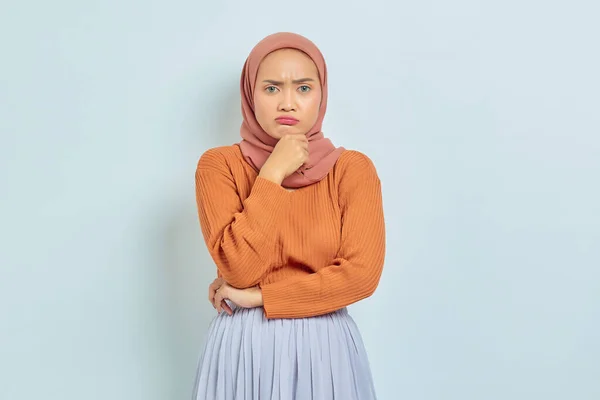 一位身穿棕色毛衣的美丽的年轻的亚洲穆斯林妇女的画像 她严肃地思考着问题 凝视着被白色背景隔离的相机 穆斯林生活方式概念 — 图库照片