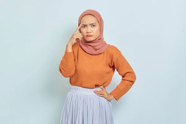 身穿棕色毛衣的年轻美丽的亚洲穆斯林妇女的画像 严肃地思考着问题 看着被白色背景隔离的相机 穆斯林生活方式概念 — 图库照片