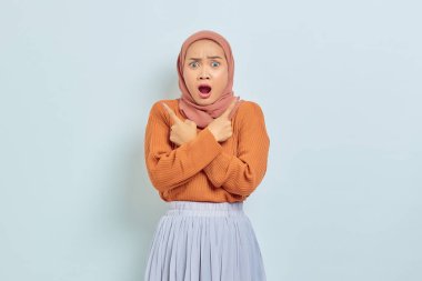 Şaşırmış Asyalı genç Müslüman kadın portresi. Ağzı açık ve parmakları çapraz. Kopya boşluğunda.