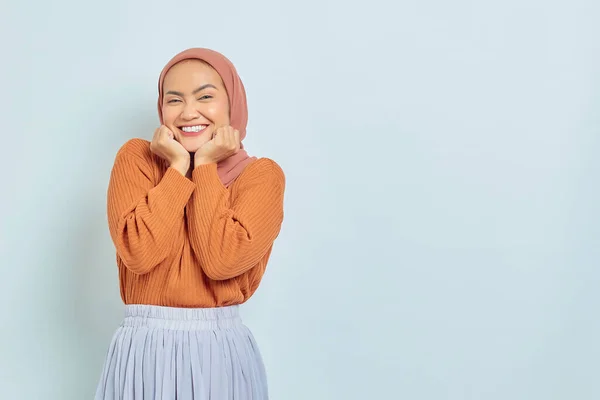 茶色のセーターを着た陽気な若いアジア系イスラム教徒の女性と白い背景に隔離されたあごの上に手のひらを置く イスラム教徒のライフスタイルコンセプト — ストック写真