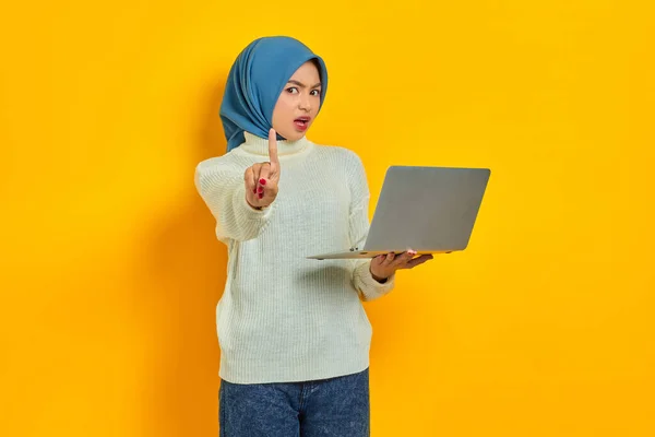 Серьёзная Молодая Азиатка Мусульманка Белом Свитере Держащая Ноутбук Показывая Стоп — стоковое фото
