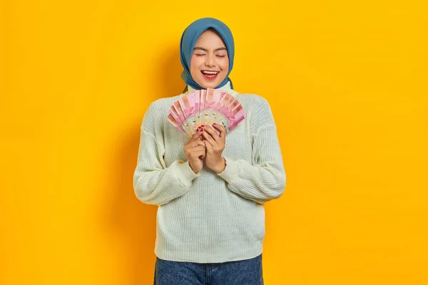 Podekscytowana Piękna Azjatycka Muzułmanka Białym Swetrze Pokazująca Gotówkę Indonezyjskich Banknotach — Zdjęcie stockowe