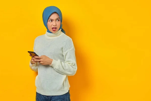 Sokkolt Fiatal Ázsiai Fehér Pulóverben Hidzsáb Segítségével Mobiltelefon Félrenéz Elszigetelt — Stock Fotó