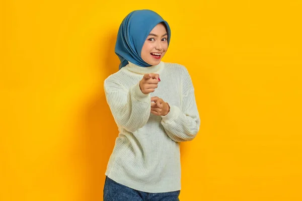 喜びました美しいですアジアの女性でホワイトセーターPointing指でカメラ絶縁上の黄色の背景 — ストック写真