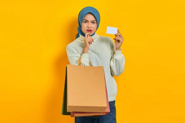 스웨터를 쇼핑백 카드를 배경에서 고립된 무엇인가를 생각하는 전반적으로 아름다운 아시아 — 스톡 사진