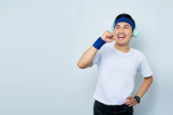 헤드폰을 파란색 머리띠와 티셔츠를 아시아 스포츠 트레이너가 배경에 고립된 마이크로 — 스톡 사진