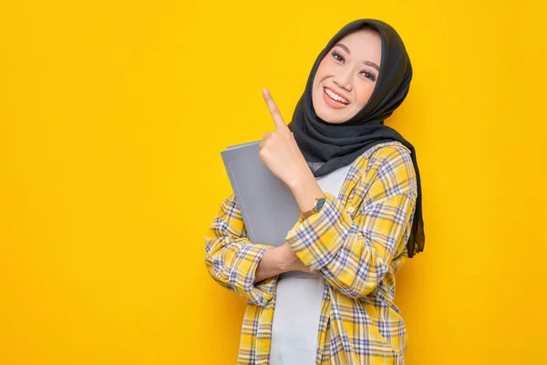 Smiling Young Asian Muslim Student Holding Book Looking Camera Pointing — Foto Stock